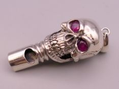 A silver skull form whistle. 4 cm long.