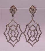 A pair of diamond drop earrings. 5.5 cm high.