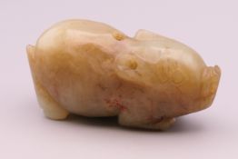 A russet jade model of a pig. 6 cm long.