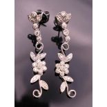 A pair of 18 ct white gold diamond flower drop earrings. Approximately 4 cm long.