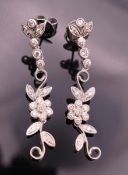 A pair of 18 ct white gold diamond flower drop earrings. Approximately 4 cm long.