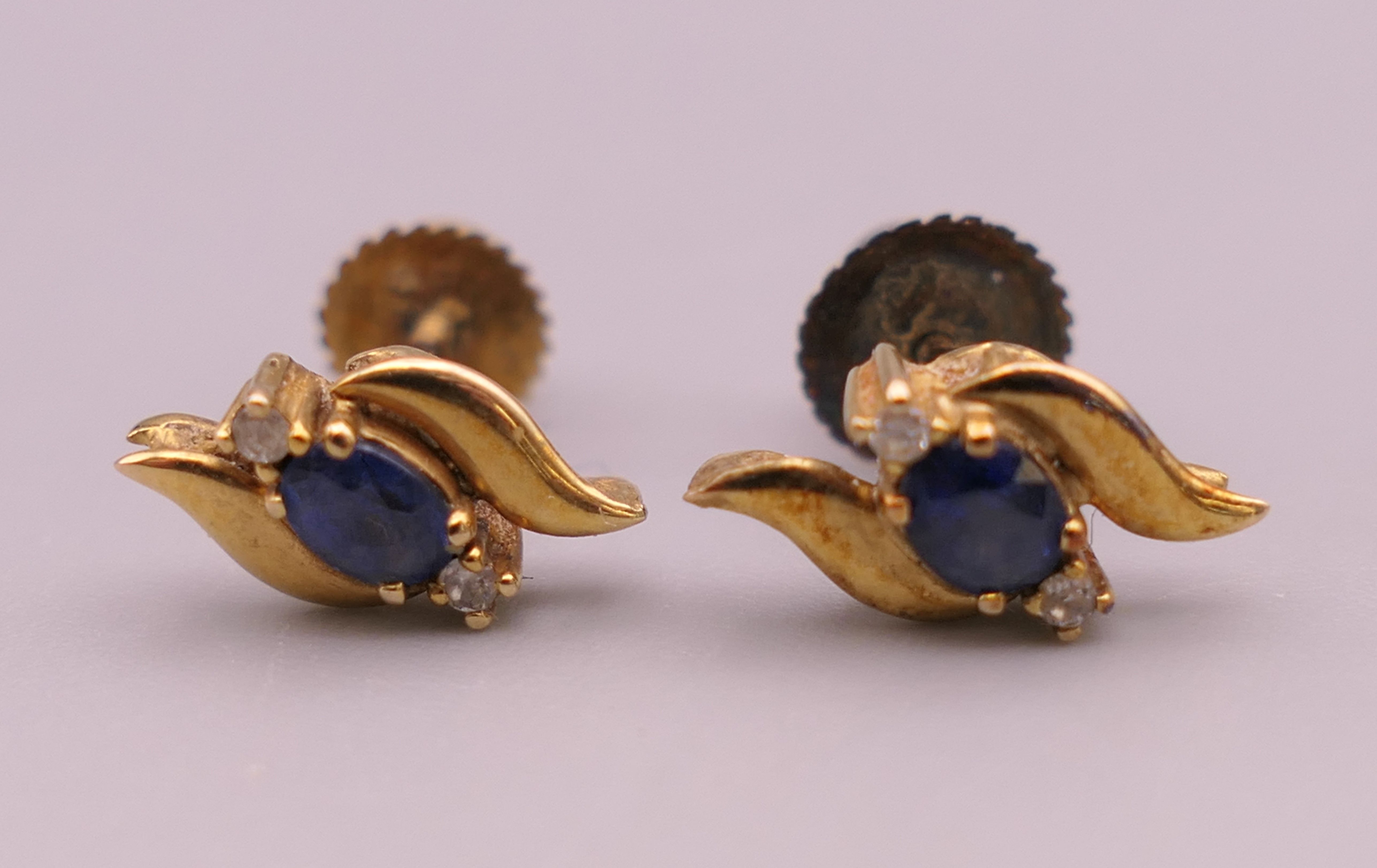 A pair of gold sapphire and diamond earrings. 1 cm high.