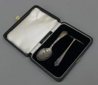 A cased silver baby pusher and spoon.