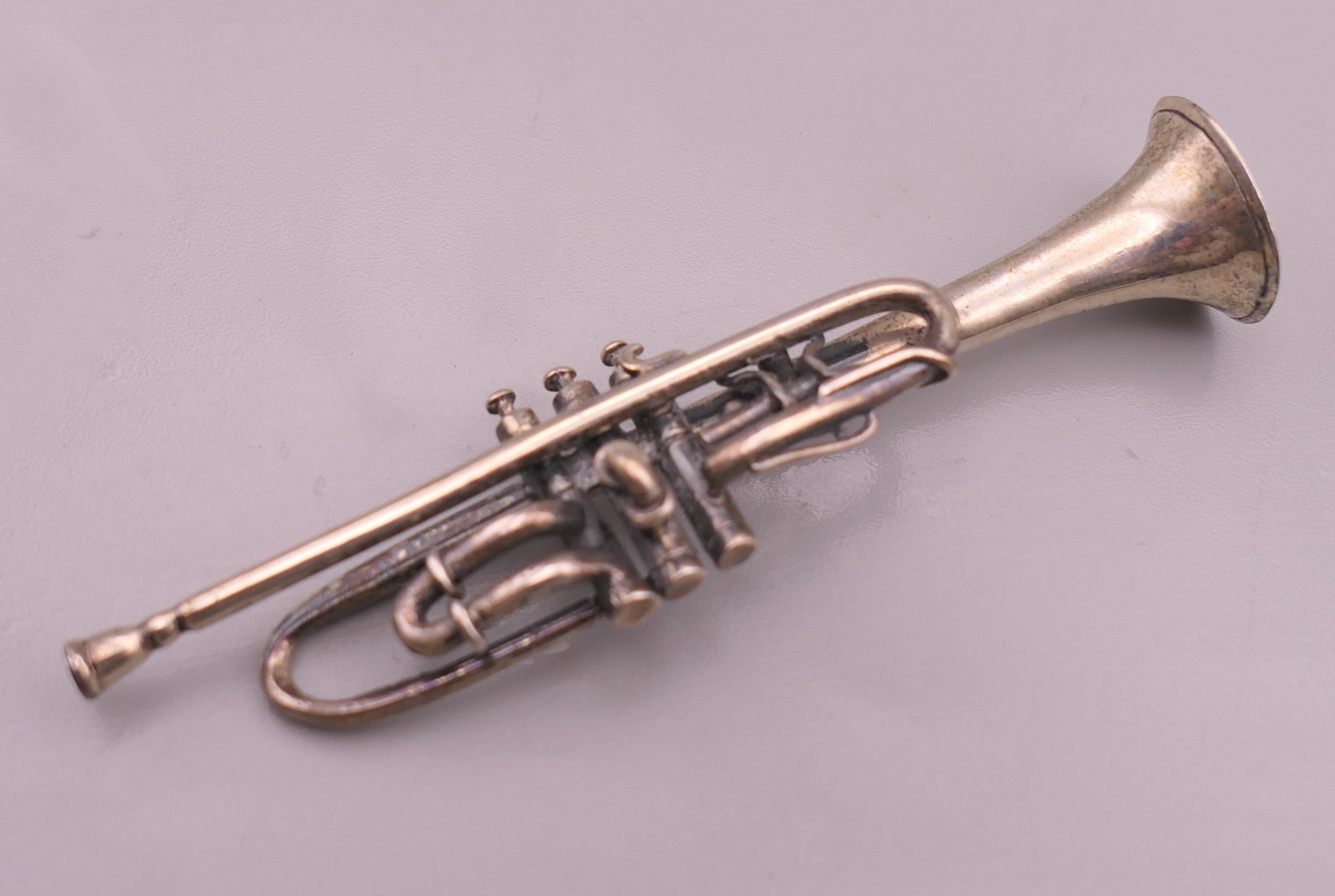 A miniature silver model of a trumpet, hallmarked for London 1993. 7.5 cm long. - Image 2 of 4