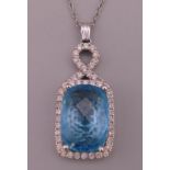 A 14 KT white gold, blue stone and diamond pendant.