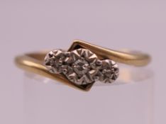 A 9 ct gold and platinum three stone diamond ring. Rings size N/O. 2.4 grammes total weight.