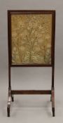 A 19th century mahogany embroidered fire screen. 50 cm wide.