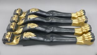 Four gilt heightened ebonised carved wooden table legs in the manner of Thomas Hope. 81 cm high.