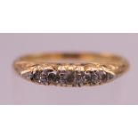 An 18 ct gold five stone diamond ring. Ring M/N. 2.8 grammes total weight.