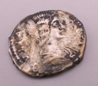 An antique silver coin. 2 cm diameter.
