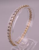 A 9 ct gold and diamond tennis bracelet. 18.5 cm long. 6.9 grammes total weight.