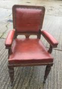 A leather upholstered oak open armchair. 58 cm wide.