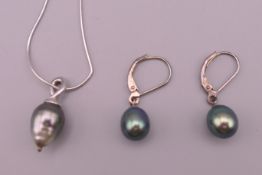 A Tahitian black pearl pendant necklace and a pair of matching earrings.