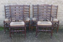 A set of six rush seated ladder back chairs, including two with arms. The latter 58 cm wide.