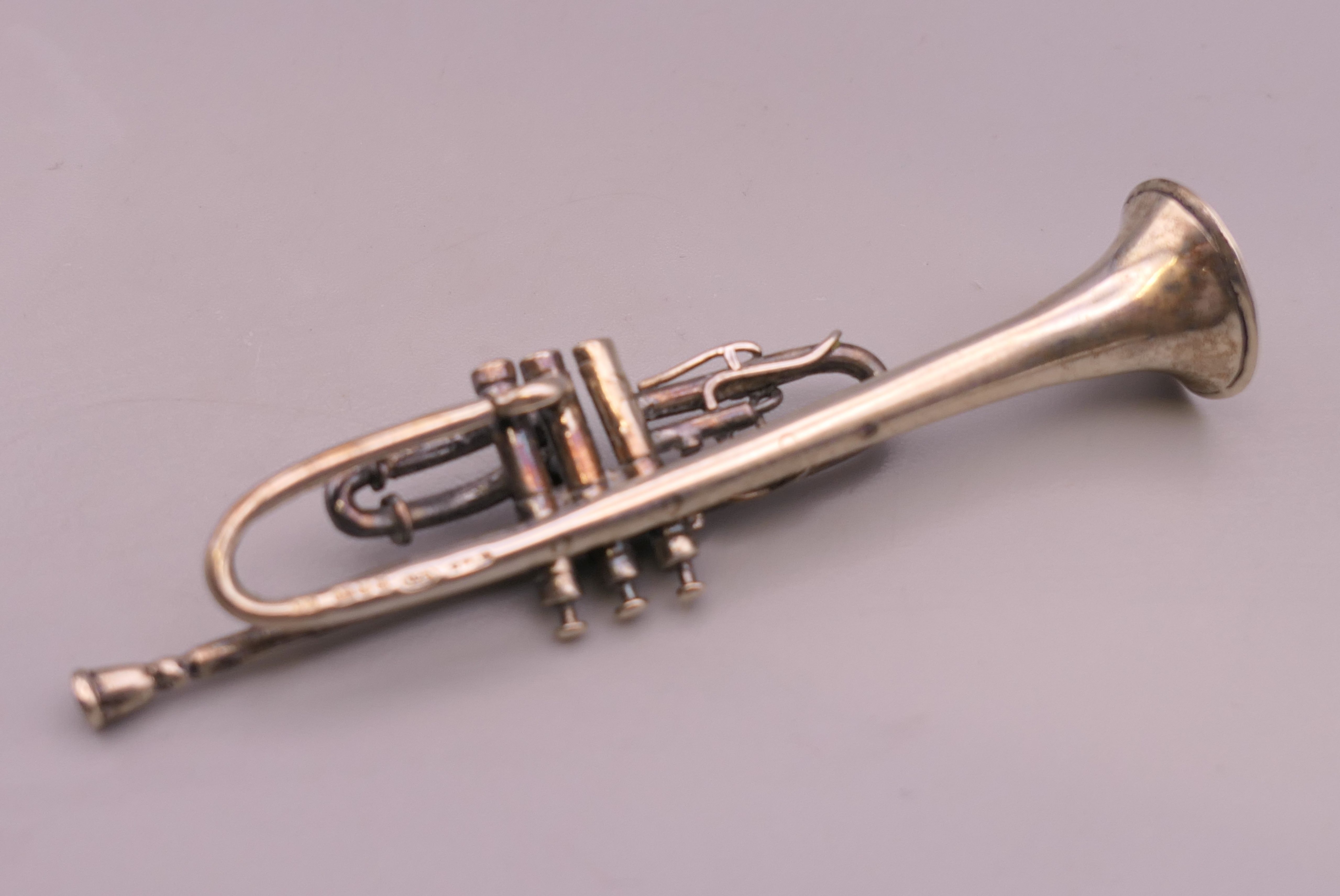 A miniature silver model of a trumpet, hallmarked for London 1993. 7.5 cm long. - Image 3 of 4