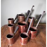 Graduated set of three copper Grain measures, cylindrical bodies with wrought iron handles, and a