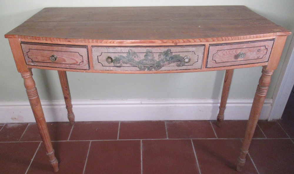 C19th pitch and waxed pine bow front side table, the three frieze drawer drawers painted with