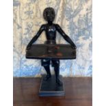 Small wooden dumbwaiter in the form of a Blackamoor carrying a rectangular papier mache tray,