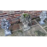 Set of three weathered composite garden ornaments, modelled as flower and fruit filled urns on