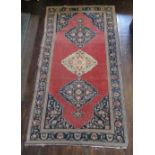 Caucasian multicoloured rug, the field filled with three joined stepped medallions on a red ground