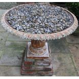 Cast iron garden urn, shallow body with lotus rim on similar baluster pedestal and stepped square