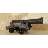 C20th cast metal model of a signal cannon, ribbed barrel on shaped carriage and spoked wheels, L23cm