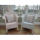 Pink painted Lloyd Loom type chair and a similar white chair, with loose cushions