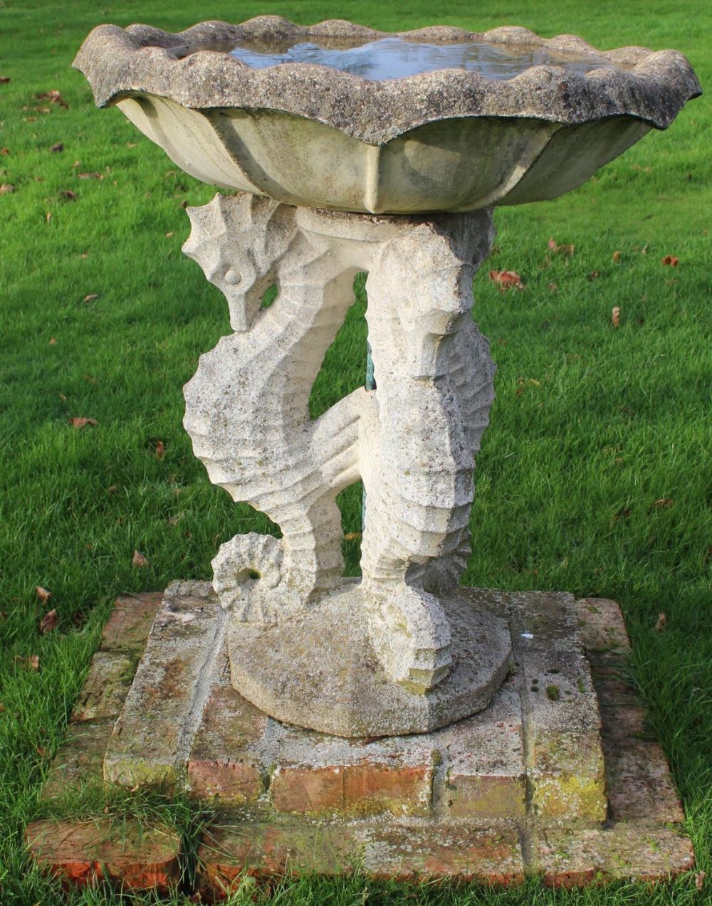 Regency Revival composite bird bath, waved edge circular top on three seahorse supports and