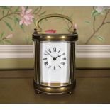 Early C20th French brass carriage timepiece, the oval reeded case with four bevelled glazed panels