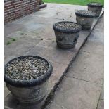 Set of three composite garden urns, tapering cylindrical banded bodies relief decorated with foliage