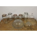 Five various Kilner type storage jars, a glass cake stand and cover and a glass cheese dome, etc