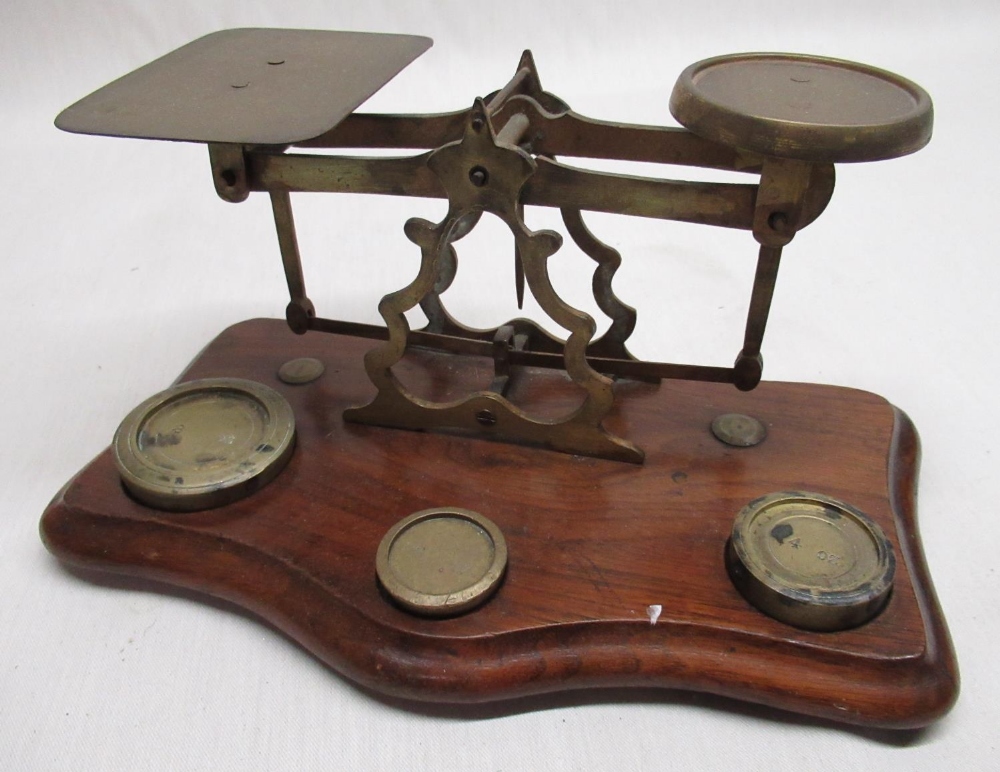 Early C20th brass postage scales pierced and shaped centre on shaped and molded mahogany base