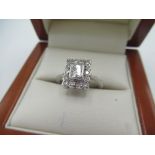 White metal and diamond ring with princess cut diamond and halo surround inset with fourteen