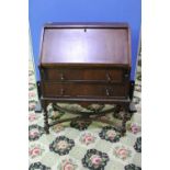 Walnut bureau with fall front revealing fitted interior above two drawers on barley twist supports