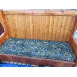 Large pine tavern type settle, loose cushions with flora and fauna pattern, brass finials W208cm
