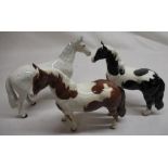 Three Beswick horse figurines, including dapple grey racehorse, skewbald pinto pony and a black