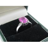 9ct white gold and pink ruby dress ring, central stone flanked by two small diamonds, size N