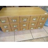 Mid C20th light oak index card chest with fifteen drawers and brass hood handles, W84cm D40cm H36cm