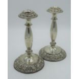 Pair of Edw.VII candlesticks, shaped columns on circular bases with repoussé detail, by Jones &