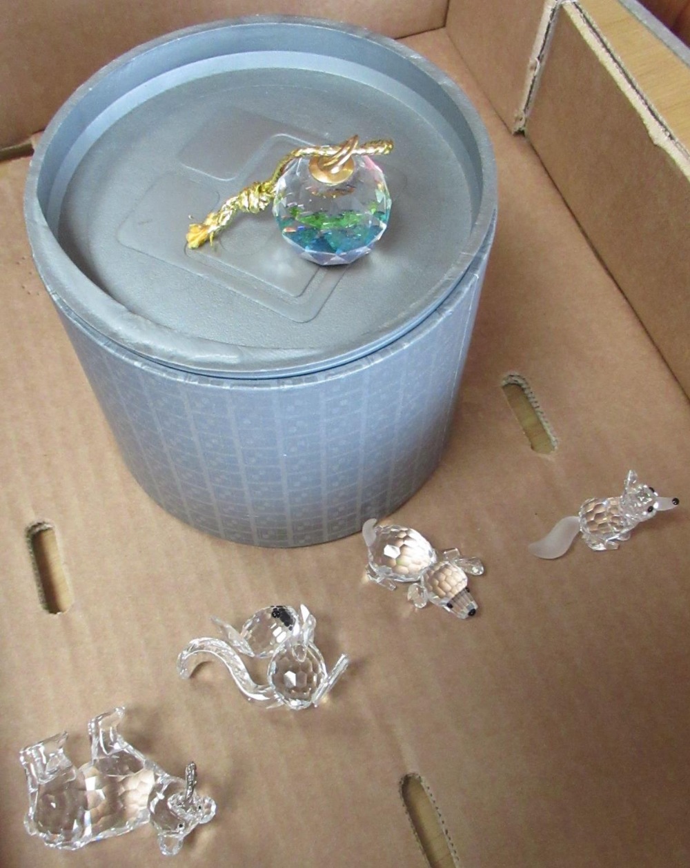 Six Swarovski crystal balls on gold coloured tassels in original boxes and a Swarovski bear cub with