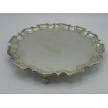 Geo.V hallmarked Sterling silver circular salver with raised Chippendale border on three scroll feet