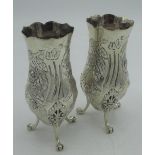 Pair of hallmarked Sterling silver bud vases repoussé decorated with foliage and flowers on three