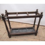 Early C20th oak three division stick stand with baluster supports on block feet with liner, W77cm