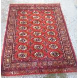 Turkoman Uzbek Bukhara rug, with 18 banked stylised guls on a rust red ground, border set with