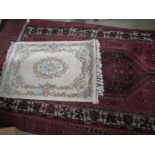 Red ground Bokhara rug, the field filled with elephants foot medallions within a multi stripe