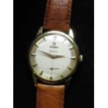 Late 1950s Omega Geneve gold cased hand wound wristwatch. Two tone silvered cross haired dial with