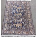 C20th Persian pattern rug, blue ground with central field set with stylized animals including deer