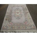 C20th Chinese embossed washed woolen rug, beige ground with central rose motifs surrounded by floral