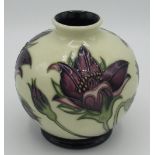 Moorcroft squat vase decorated in a tube lined pattern of a purple flower on cream background, H10.