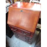 Small modern mahogany bureau with fall front revealing fitted interior above four drawers on bracket